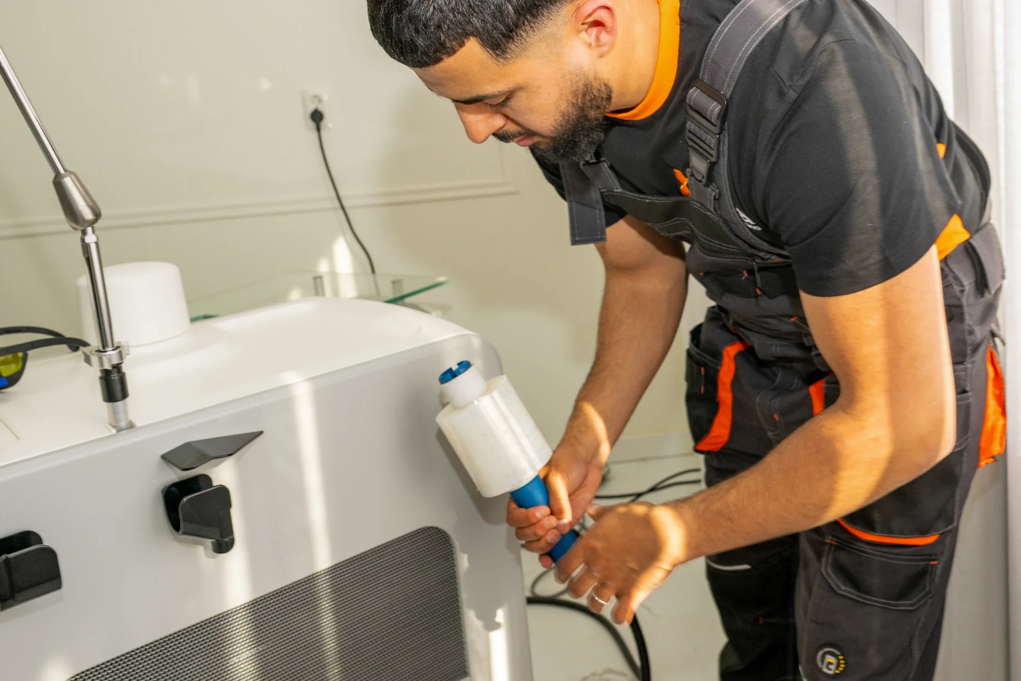 A Nova employee wrapping protective film around a large appliance in commercial premises